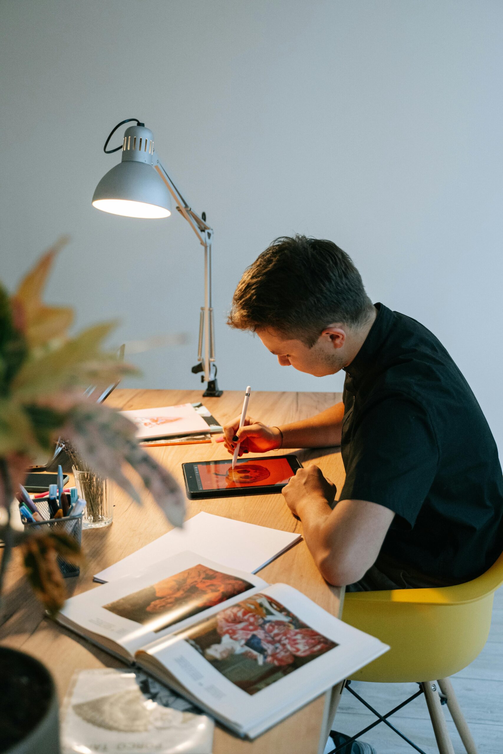 Young professional focusing on digital art project in a stylish workspace.